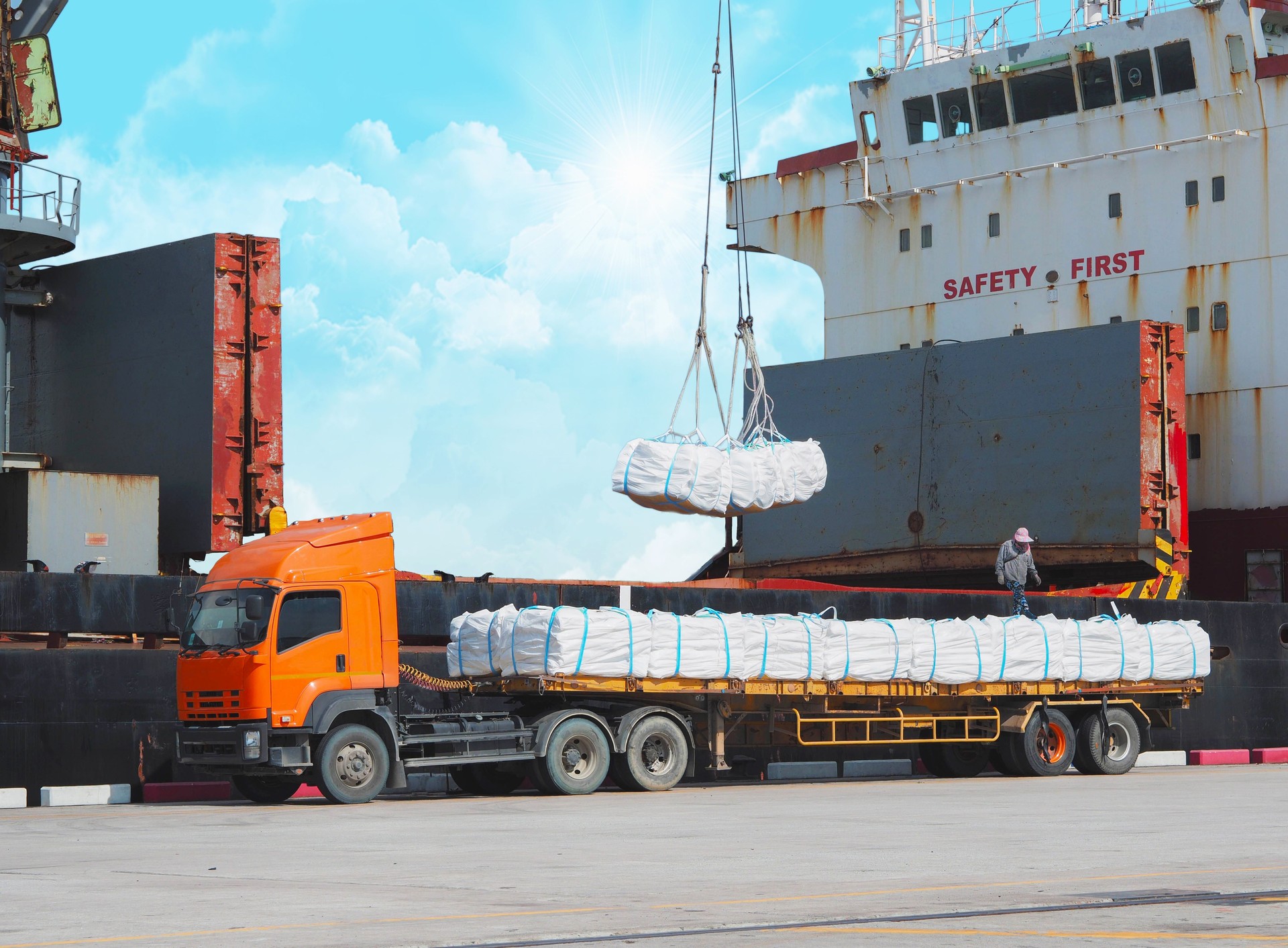 Loading sugar bag product to vessel activities at port, vessel crane pick jumbo bag from trailer load to vessel hole. Agriculture product import export