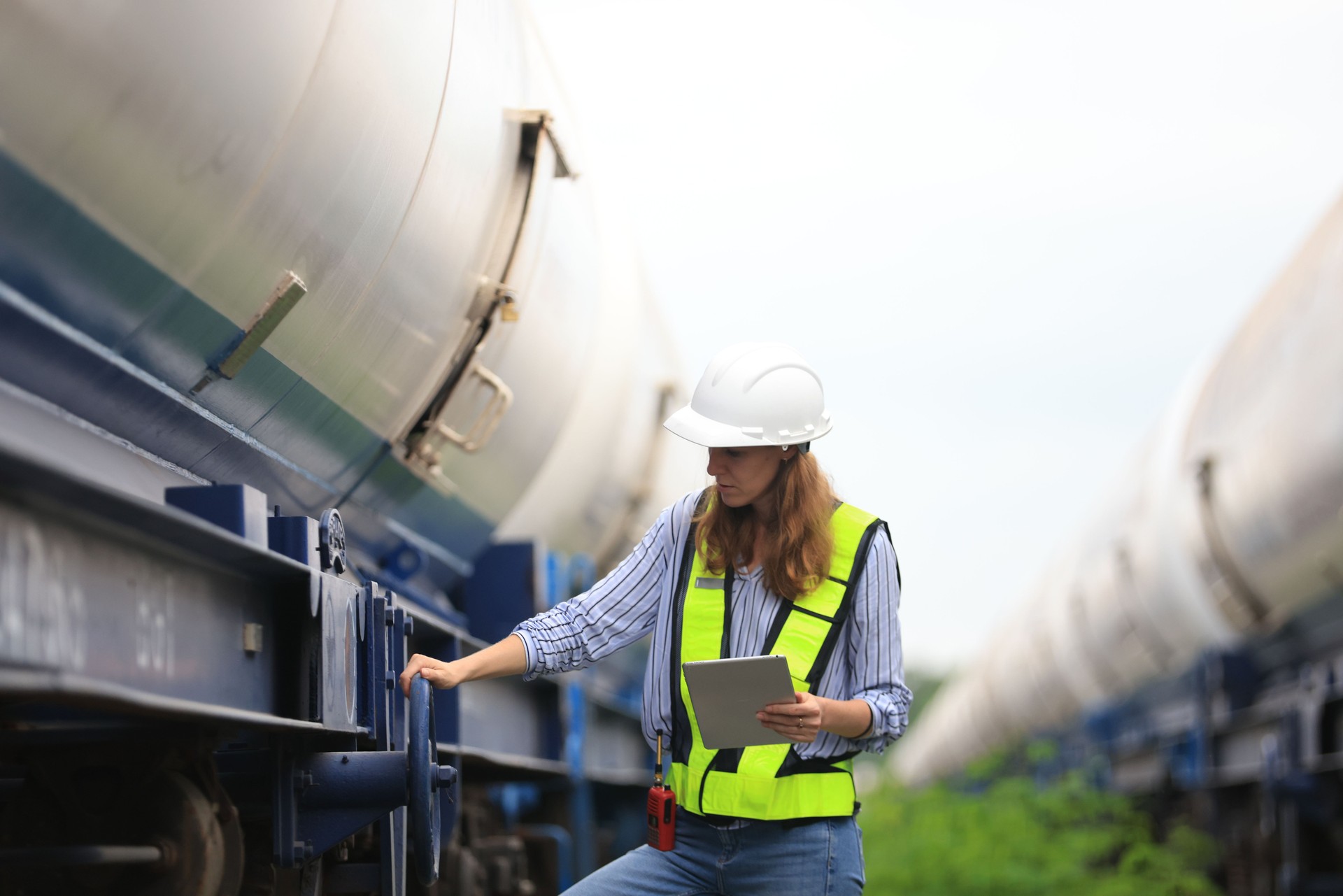 Female warehouse and chemical arrangement  senior engineer working at  A station designed for transporting oil and gas products in specialized tanks, utilizing train transport on tracks